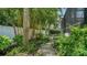 Lush backyard landscape with walking path, bamboo, and manicured greenery, providing a serene outdoor experience at 413 Partridge Cir, Sarasota, FL 34236