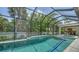 Inviting screened pool area with lush landscaping and seamless access to indoor and outdoor living spaces at 413 Partridge Cir, Sarasota, FL 34236