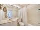 Bright bathroom with a large mirror and tub with shower, blending style and functionality at 4211 Caddie E Dr # 202, Bradenton, FL 34203
