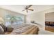 Inviting bedroom featuring a ceiling fan and a serene lake view from the expansive window at 4211 Caddie E Dr # 202, Bradenton, FL 34203
