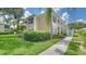 Inviting exterior view of a two-story condo with lush landscaping and charming turquoise shutters at 4211 Caddie E Dr # 202, Bradenton, FL 34203