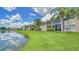 Beautiful backyard view featuring a pond, manicured lawn, and lush landscaping at 4211 Caddie E Dr # 202, Bradenton, FL 34203