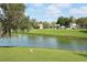 Picturesque view of a golf course with waterfront, complemented by trees and clear sky at 4211 Caddie E Dr # 202, Bradenton, FL 34203