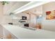 Efficient kitchen features white cabinets, a breakfast bar, and views to the dining area at 4211 Caddie E Dr # 202, Bradenton, FL 34203