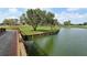 Scenic view of a pond with lush green surroundings and mature trees, enhancing the community's tranquil appeal at 4211 Caddie E Dr # 202, Bradenton, FL 34203