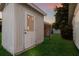 Exterior of outbuilding, with a door surrounded by green grass and foliage at 4232 Pandora Rd, Venice, FL 34293