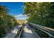 Wooden boardwalk leading to a sandy beach with lush tropical foliage at 4232 Pandora Rd, Venice, FL 34293