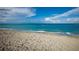 Serene beach scene with calm ocean water meeting the sandy shore under a sunny sky at 4232 Pandora Rd, Venice, FL 34293