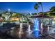 Community fountain with illuminated water jets, benches, and nearby buildings at 4232 Pandora Rd, Venice, FL 34293
