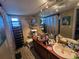 Bathroom featuring a double vanity, large mirror, toilet, and a window with shelves at 4343 Arrow Ave, Sarasota, FL 34232