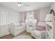 A charming Bedroom with a white crib, cozy armchair, and soft pink accents at 4344 Bent Tree Blvd, Sarasota, FL 34241