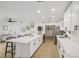 Open kitchen area with stainless steel appliances, island seating, and wood flooring at 4344 Bent Tree Blvd, Sarasota, FL 34241