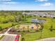 Aerial view of the community playground area, homes, pond, trees, and surrounding landscape at 4405 Weathered Moss Gln, Palmetto, FL 34221