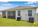 Home's backyard showing a screened-in lanai, AC unit, grill, and manicured lawn at 4405 Weathered Moss Gln, Palmetto, FL 34221