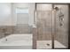 Clean bathroom showcasing a garden tub and glass-enclosed shower with tile surround at 4405 Weathered Moss Gln, Palmetto, FL 34221