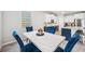 Dining room with white marble table and blue upholstered chairs near kitchen at 4405 Weathered Moss Gln, Palmetto, FL 34221