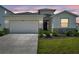 Charming single-story home showcasing manicured landscaping, a two-car garage, and a welcoming entrance at 4405 Weathered Moss Gln, Palmetto, FL 34221
