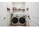 Laundry room with washer, dryer, shelving, and door open showcasing additional space at 4405 Weathered Moss Gln, Palmetto, FL 34221