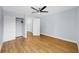 A cozy bedroom with light blue walls, wood-look floors, and a ceiling fan and closet at 4455 Emerald Ridge Dr, Sarasota, FL 34233