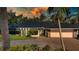 Charming single-story home featuring a black roof, stone accents, paved driveway, and lush landscaping at 483 Partridge Cir, Sarasota, FL 34236