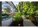 Beautifully landscaped backyard with a screened-in pool and brick pathway at 483 Partridge Cir, Sarasota, FL 34236