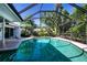 Relaxing screened-in pool with clear blue water and tranquil backyard views at 483 Partridge Cir, Sarasota, FL 34236
