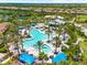 Resort-style aerial view featuring a large pool surrounded by palm trees, lounging cabanas, and other community buildings at 5121 Serata Dr, Lakewood Ranch, FL 34211