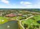 Expansive aerial view of a golf course community featuring lush greenery, a lake, and residential homes at 5121 Serata Dr, Lakewood Ranch, FL 34211