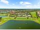 Panoramic aerial view showcases a golf course community with a lake, pool, tennis courts, and lush landscaping at 5121 Serata Dr, Lakewood Ranch, FL 34211