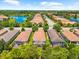 Aerial view of homes with screened patios, lush landscaping, and community lake at 5121 Serata Dr, Lakewood Ranch, FL 34211