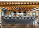 An elegant and modern bar area featuring a dark countertop, comfortable seating, and a stylish wooden beam ceiling at 5121 Serata Dr, Lakewood Ranch, FL 34211
