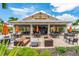 Outdoor Bahama Bar with tables, chairs, lounge seating and a square fire pit under a sunny sky at 5121 Serata Dr, Lakewood Ranch, FL 34211