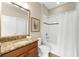 Bright bathroom featuring granite vanity top, framed mirror and a shower with curtain rod at 5121 Serata Dr, Lakewood Ranch, FL 34211