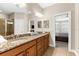 Bathroom featuring granite countertops, double sinks, framed mirrors and an adjacent bedroom at 5121 Serata Dr, Lakewood Ranch, FL 34211