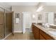 Spacious bathroom features a walk-in shower, double sink vanity with granite countertops, and access to the walk-in closet at 5121 Serata Dr, Lakewood Ranch, FL 34211