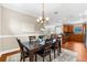 Open dining room featuring a dark wood table, seating for six, and an open view to the kitchen at 5121 Serata Dr, Lakewood Ranch, FL 34211