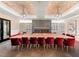 A stylish dining room features a large table with red chairs, a fireplace, and modern art, ideal for gatherings at 5121 Serata Dr, Lakewood Ranch, FL 34211