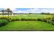 Lush golf course with manicured lawns, a serene lake, and tropical palm trees against a clear blue sky at 5121 Serata Dr, Lakewood Ranch, FL 34211