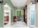 A well lit hallway leads to a salon and office, offering a relaxing atmosphere with lush greenery at 5121 Serata Dr, Lakewood Ranch, FL 34211