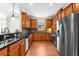 Well-lit kitchen with stainless steel appliances, wood cabinets, granite counters, and tiled backsplash at 5121 Serata Dr, Lakewood Ranch, FL 34211