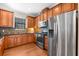 Kitchen featuring stainless steel appliances, wood cabinets, granite countertops, and decorative tile backsplash at 5121 Serata Dr, Lakewood Ranch, FL 34211