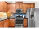 Kitchen featuring stainless steel appliances, wood cabinets, granite countertops, and decorative tile backsplash at 5121 Serata Dr, Lakewood Ranch, FL 34211