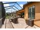 Spacious screened lanai offering outdoor seating and a dining table near the home's window at 5121 Serata Dr, Lakewood Ranch, FL 34211