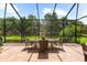 View of screened lanai featuring a dining table set overlooking the lush green lawn at 5121 Serata Dr, Lakewood Ranch, FL 34211