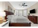 Bright main bedroom with shuttered windows, ceiling fan, television and dresser at 5121 Serata Dr, Lakewood Ranch, FL 34211