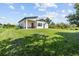 Expansive backyard view showcasing well-manicured lawn, contemporary home design, and lush landscaping at 5339 Gulfport Ter, Port Charlotte, FL 33981