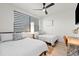 A naturally lit bedroom features two twin beds, a ceiling fan and hardwood flooring at 5339 Gulfport Ter, Port Charlotte, FL 33981