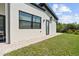 A serene backyard setting features a lush lawn, a brick paver pathway, and contemporary architecture at 5339 Gulfport Ter, Port Charlotte, FL 33981