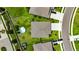 Birds-eye-view of a suburban home with a backyard pool, green lawn, and surrounding houses in the neighborhood at 5521 Olano St, Palmetto, FL 34221