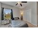 Carpeted bedroom with ceiling fan, closet, and lamp next to a bed by the window and dresser at 5521 Olano St, Palmetto, FL 34221